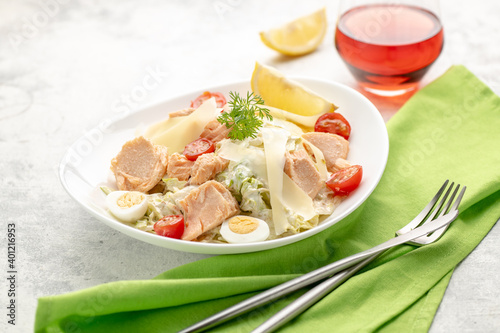 Salad with baked salmon. A large portion of salad with red fish, fresh vegetables, eggs, cherry tomatoes and lemon.