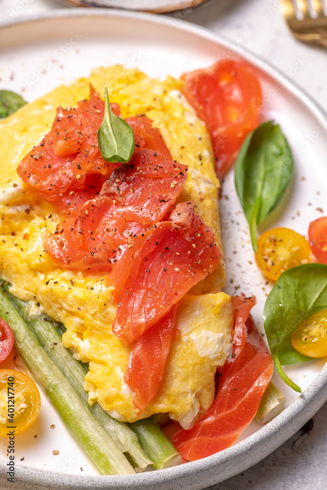 Fried eggs with green asparagus and salmon, cherry tomatoes and fresh spinach. Fried eggs with green asparagus and salmon, cherry tomatoes and fresh spinach.