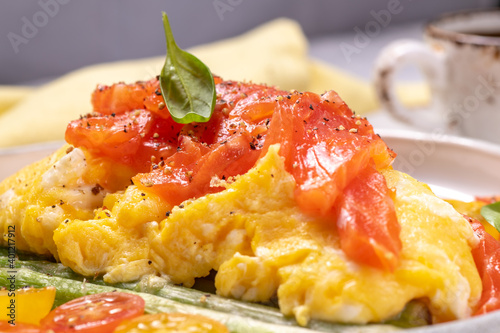 Fried eggs with green asparagus and salmon, cherry tomatoes and fresh spinach.