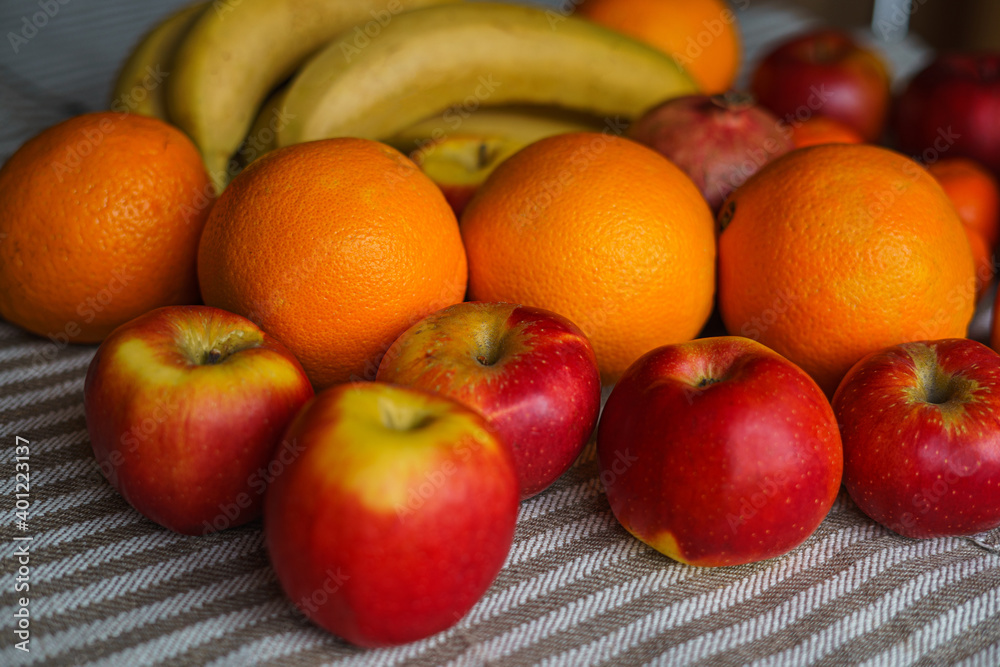 Many different fresh fruits are on the table on a mottled light canvas