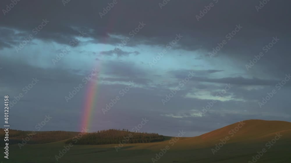 Rainbow in the Mongolian meadows at sunrise.Sunup at dawn twilight early morning day before after time Mongolia Mongolian Siberian Siberia Central Asia grassland prairie moorland meadow wold pasture Rainbow in the Mongolian meadows at sunrise.Sunup at dawn twilight early morning day before after time Mongolia Mongolian Siberian Siberia Central Asia grassland prairie moorland meadow wold pasture