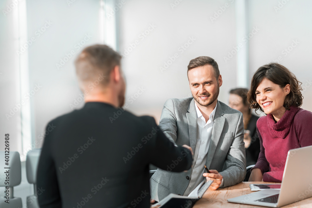 young businessmen confirm the deal with a handshake young businessmen confirm the deal with a handshake
