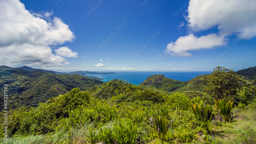 A tropical island. Mountains covered with tropical vegetation, turquoise water of the sea that washes green shores.