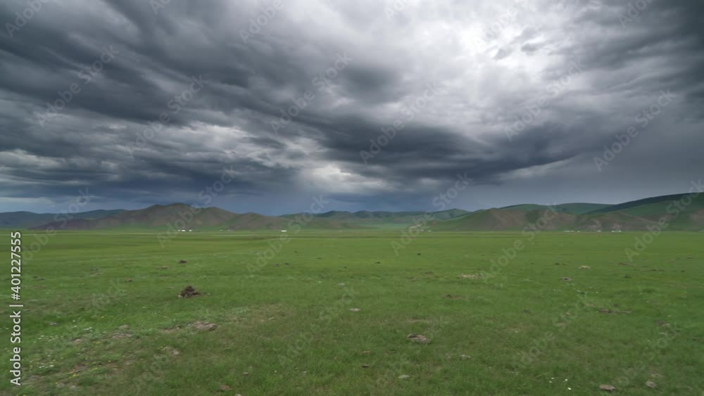 Flat Central Asian meadow in dark overcast cloudy weather.Grassland prairie moorland wold pasture steppe plateau tableland lowland plain treeless vast extensive unlimitedness immensity large approachi Flat Central Asian meadow in dark overcast cloudy weather.Grassland prairie moorland wold pasture steppe plateau tableland lowland plain treeless vast extensive unlimitedness immensity large approachi