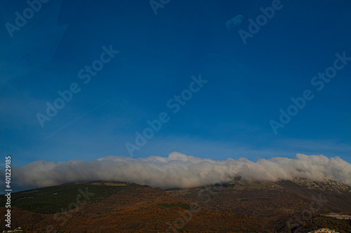 Nuvole appoggiate sulla cima delle montagne dell'appennino Umbro-Marchigiano 