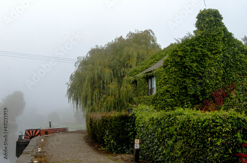 house along the canal in the fog