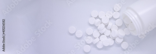 Top view White pills spilling out of pill bottle on isolated white background with copy space photo