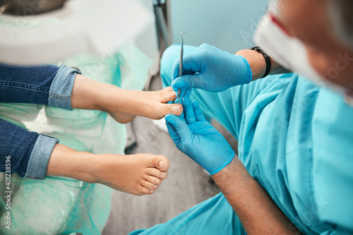 Unrecognized female patient in the process of hardware pedicure procedure