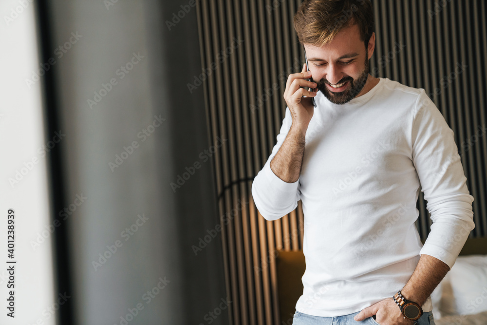 Attractive smiling young man using mobile phone Attractive smiling young man using mobile phone