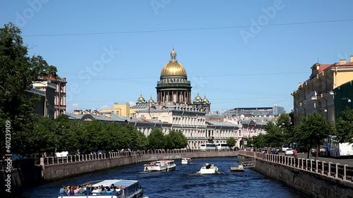 View of the Moika river embankments, the domes of St. Isaac's Cathedral and tourist boats, St. Petersburg, Russia
