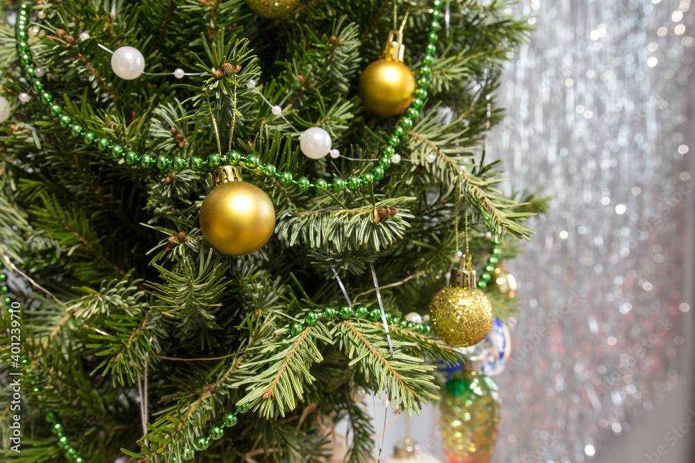 Fototapeta premium green decorated christmas tree with golden balls on gray background