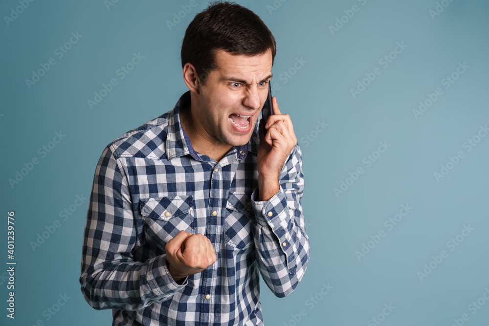 Portrait of an angry unsatisfied man using mobile phone Portrait of an angry unsatisfied man using mobile phone