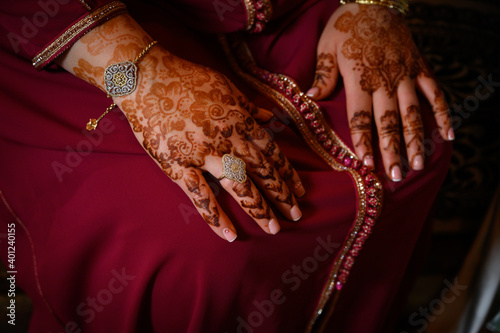 Manos de mujer con anillos y joyas diseño en con henna vestido típico indio o arabe de color rojo y decoración