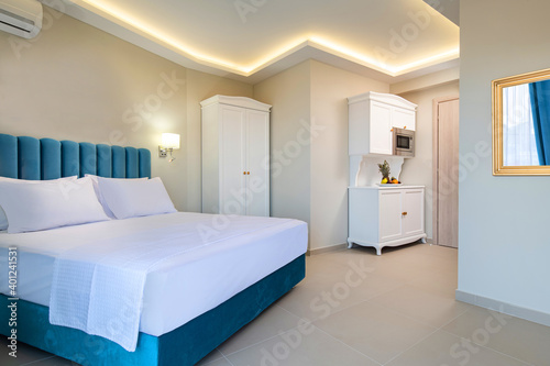 Classic style interior of white and blue bedroom with kitchen cupboard module cabinet in double suite hotel apartment flat