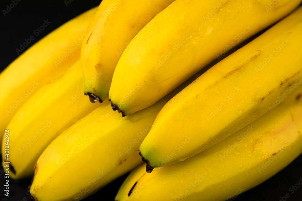 
A large branch of bananas on a black background.
Close-up.