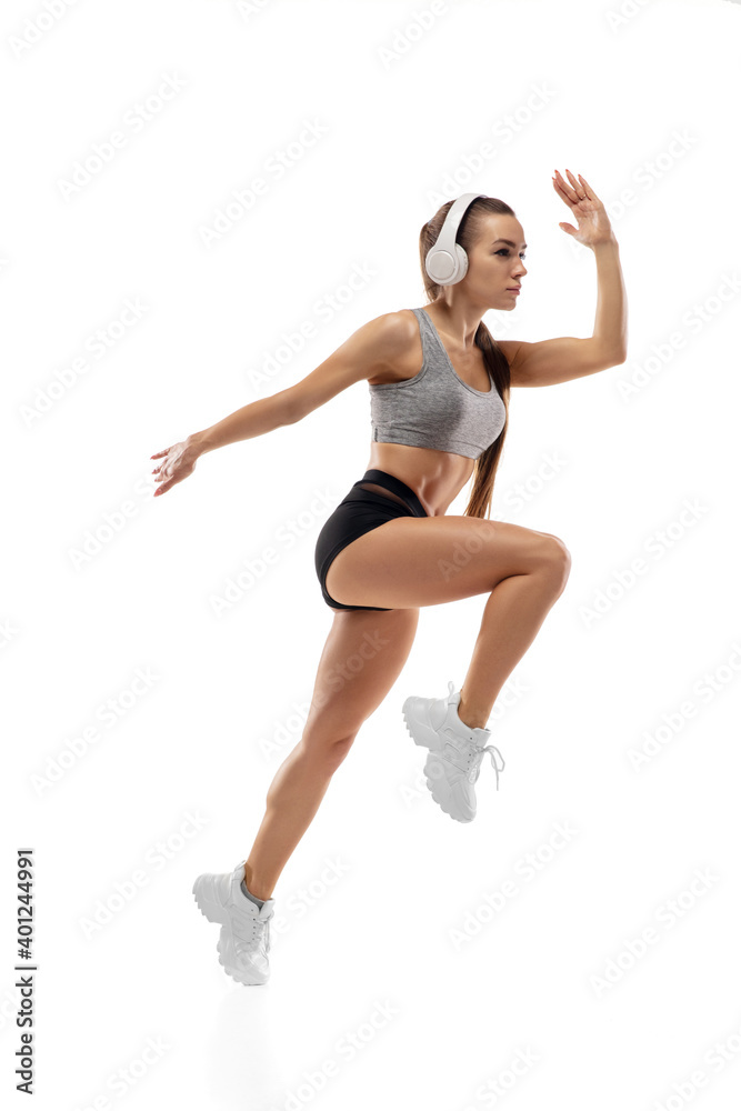 Jump up. Caucasian professional female athlete, runner training isolated on white studio background. Muscular, sportive woman. Concept of action, motion, youth, healthy lifestyle. Copyspace for ad.