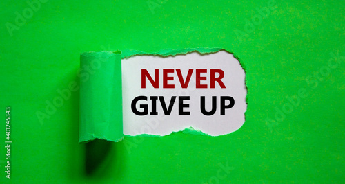 Never give up symbol. Words 'Never give up' appearing behind torn green paper. Business and 'never give up' concept. Copy space.
