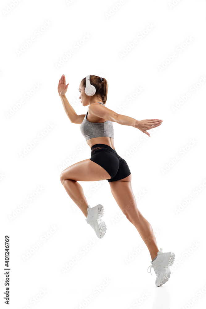 Dynamic. Caucasian professional female athlete, runner training isolated on white studio background. Muscular, sportive woman. Concept of action, motion, youth, healthy lifestyle. Copyspace for ad.
