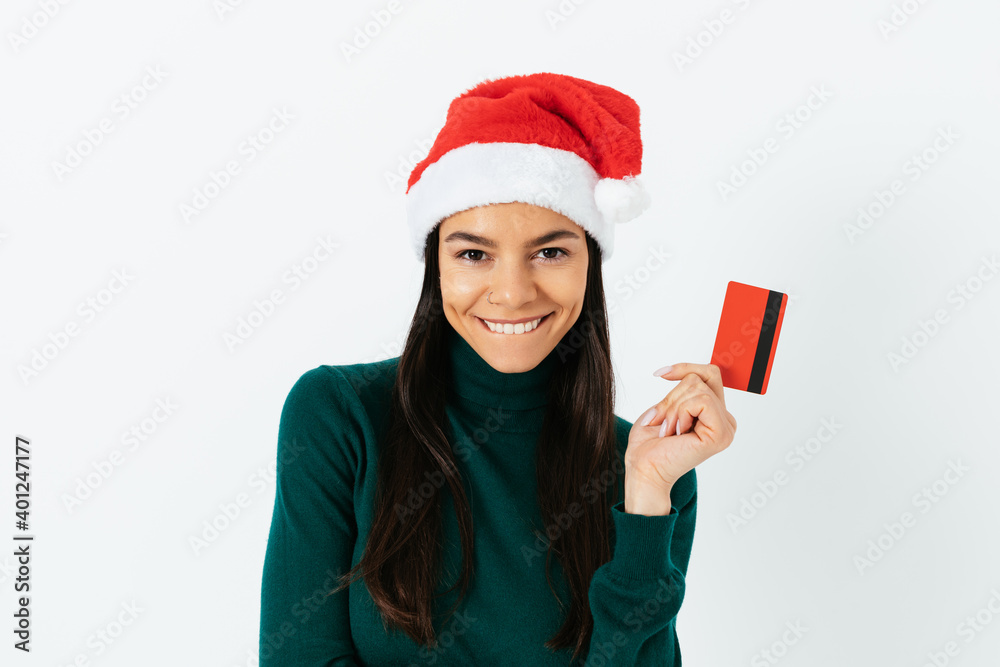 Cheerful woman in a santa hat and with a bank card Cheerful woman in a santa hat and with a bank card