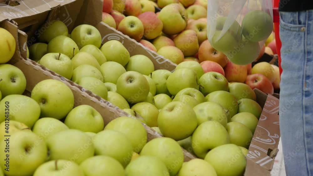 Young woman choosing green apples in eco bag at the fruit and vegetable supermarket market Young woman choosing green apples in eco bag at the fruit and vegetable supermarket market