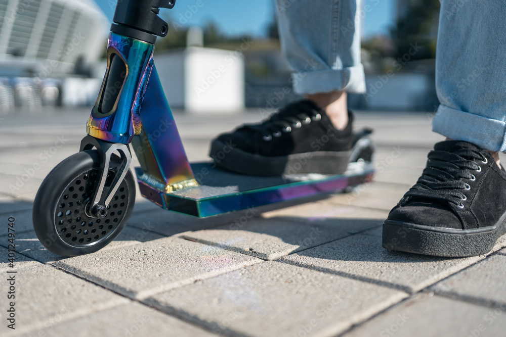 young teenager in sneaker on modern extreme stunt kick scooter in skatepark young teenager in sneaker on modern extreme stunt kick scooter in skatepark