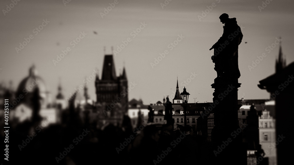 Fototapeta premium Künstlerisch gestaltete Schwarz-Weiß-Aufnahmen von Prag: Brückenfigur und Stadtsilhouette
