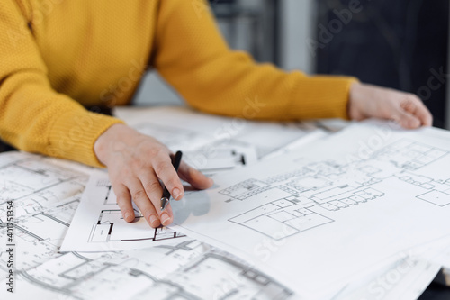 Woman working at office with blueprint and documents