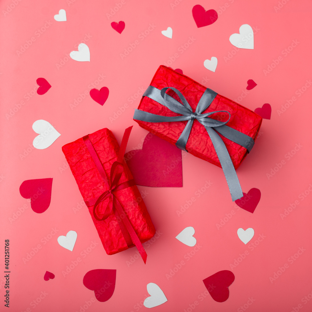 Two gifts for valentine's day. Boxes in red packaging on a pink background with hearts. Two gifts for valentine's day. Boxes in red packaging on a pink background with hearts.