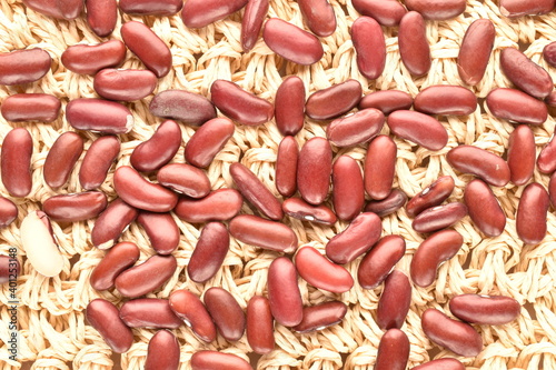 Uncooked red beans, on a straw mat, close-up