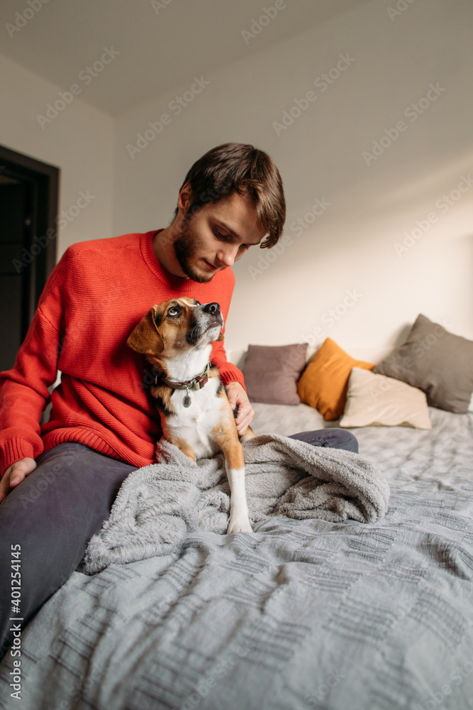 happy man with cute dog in bedroom on bed