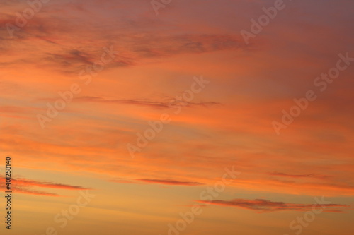 Sun below the horizon and clouds in the fiery dramatic orange sky at sunset or dawn backlit by the sun. Place for text and design © Stanislav