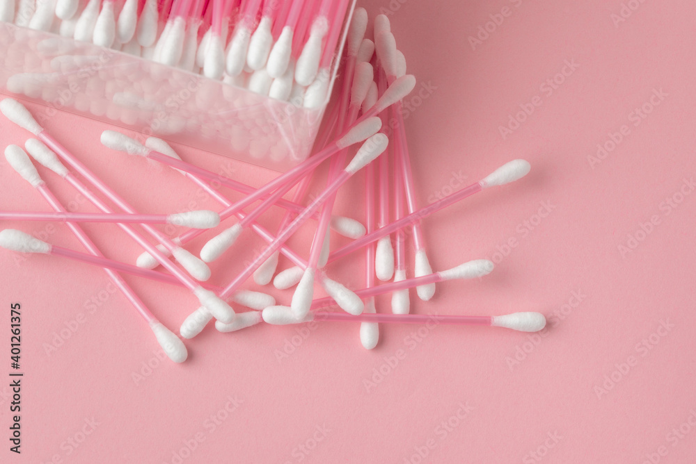Macro photography of several pink cotton buds in open plastic box on a pink background. Cotton swabs clouse up with copy space Macro photography of several pink cotton buds in open plastic box on a pink background. Cotton swabs clouse up with copy space