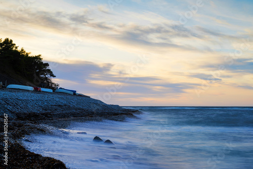 Sunset over a cold deep blue Baltic Sea with a cobblestone beach in the foreground at island of Gotland in Sweden photo