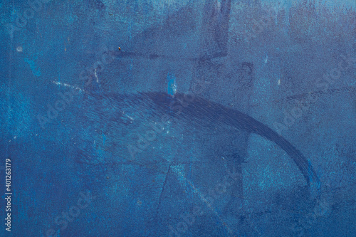 The fine texture of a wooden surface with a sloppy blue paint.