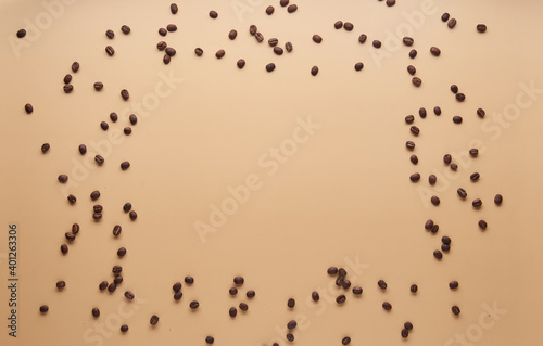 Frame of coffee beans isolated on beige background. Copy space, top view, flat lay.