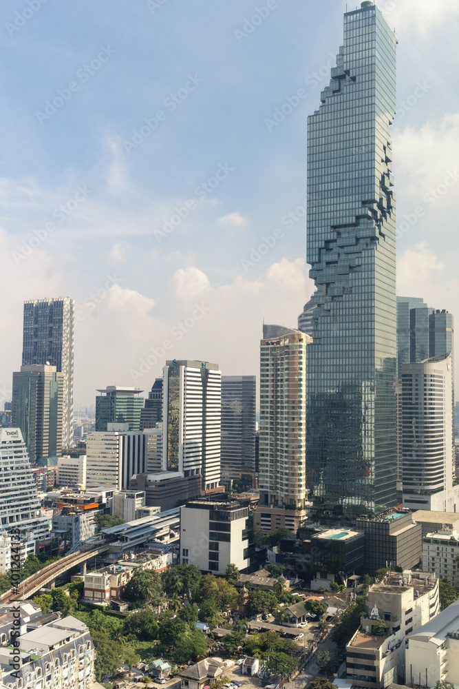 Modern city view with high buildings and towers under the blue sky.