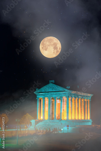 Night view of the pagan temple of Garni on the background of the moon, in fog and smoke, Hellenistic temple in the Republic of Armenia. photo