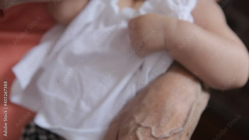 Close=up of Hispanic grandfather holding and feeding a newborn baby granddaughter with a bottle Close=up of Hispanic grandfather holding and feeding a newborn baby granddaughter with a bottle