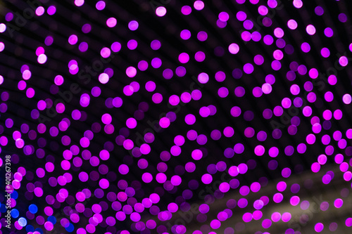 Christmas and New Year festive glitter bokeh background with purple, pink and blue colors. © Parviza