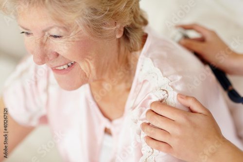 Nurse examining patient with a stethoscope photo