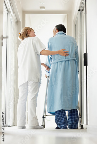 Nurse assisting patient with a walker photo