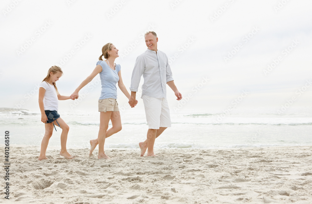 Girl (10-11) walking on beach with parents Girl (10-11) walking on beach with parents