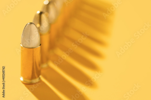 Row of gold bullets on yellow background photo