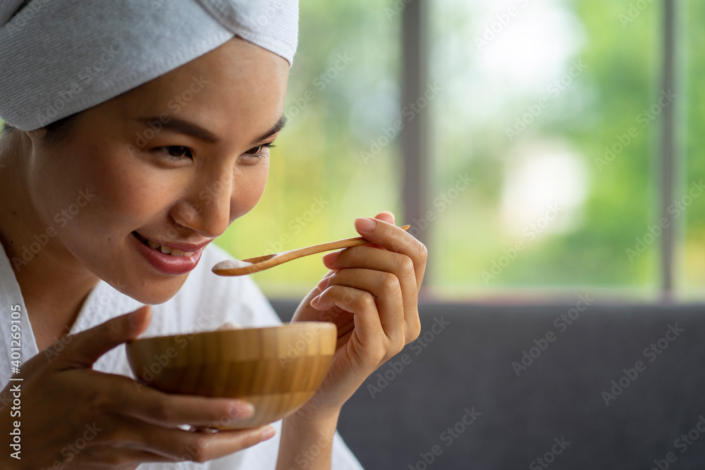 Asian pretty young woman wearing bathrobe sitting on couch in spa resort for massage and skin care Asian pretty young woman wearing bathrobe sitting on couch in spa resort for massage and skin care