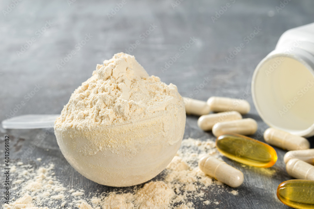 Scoop of whey or soy protein isolate, omega-3 capsules, white pills of bcaa, beta-alanine and taurine amino acids, creatine, bodybuilding food supplements on stone background Scoop of whey or soy protein isolate, omega-3 capsules, white pills of bcaa, beta-alanine and taurine amino acids, creatine, bodybuilding food supplements on stone background