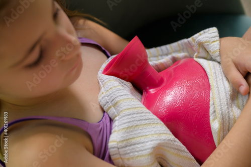 Girl (6-7) holding hot water bottle photo