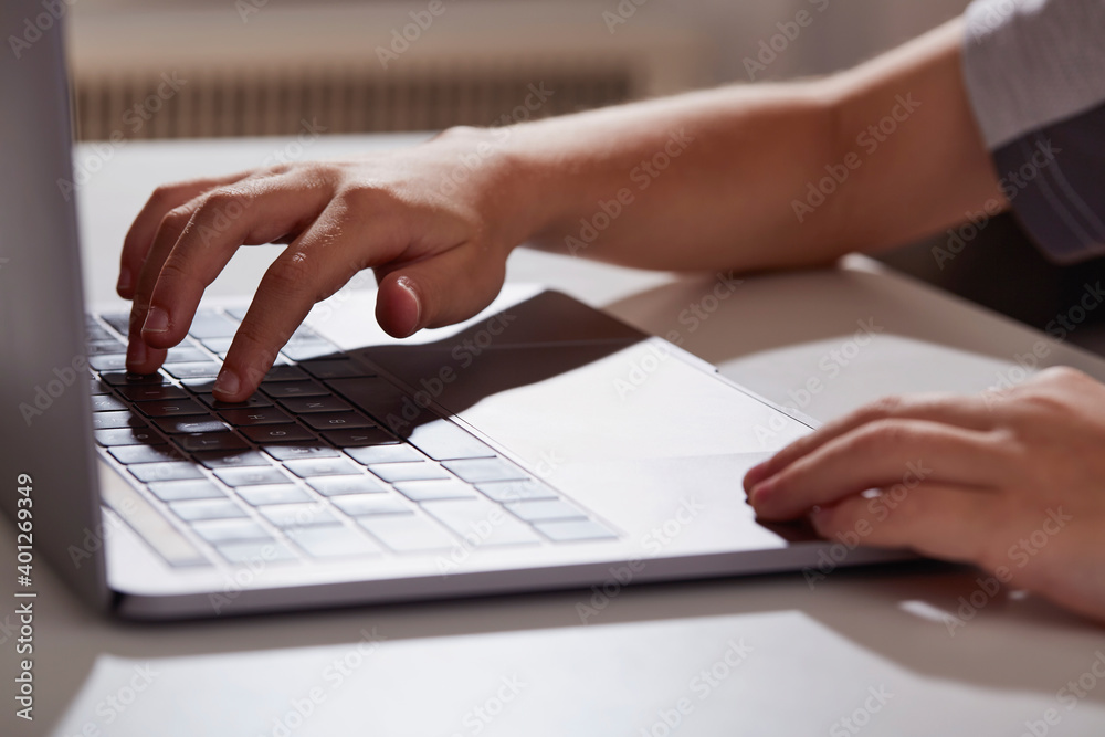 Close-up of boys (8-9) hands typing on laptop
