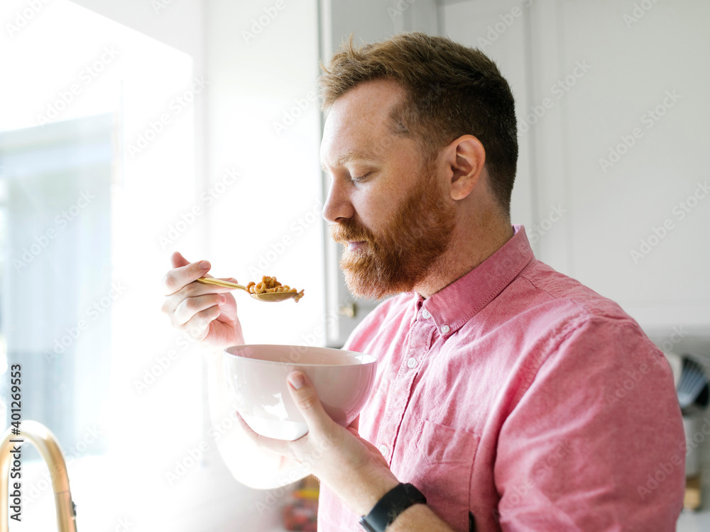 Man eating cereal breakfast in kitchen Man eating cereal breakfast in kitchen