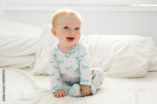 Baby boy (6-11 months) lying on bed
