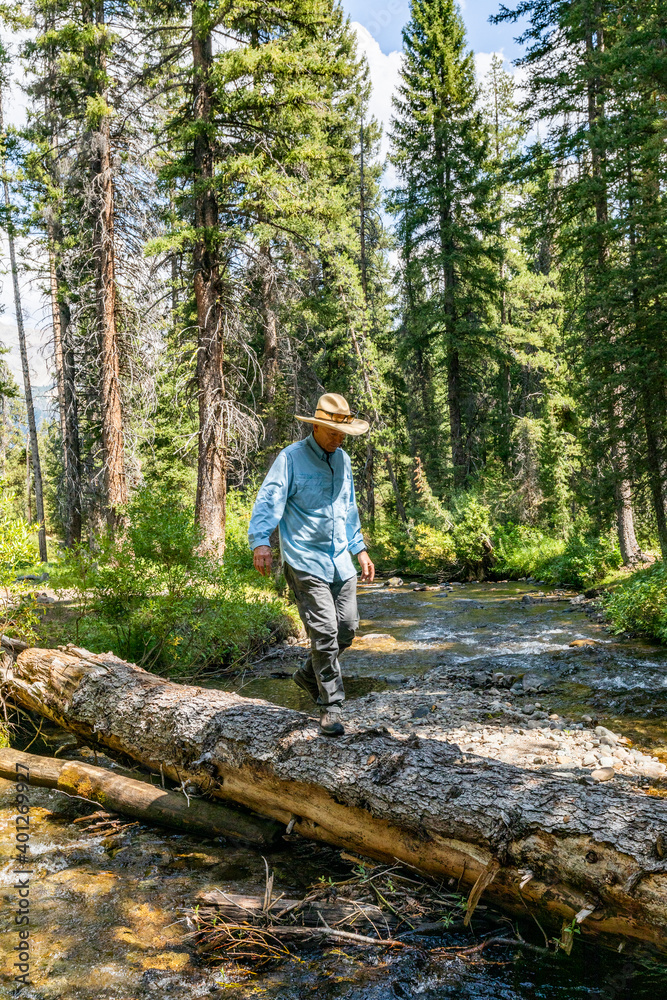 USA, Idaho, Sun Valley, Man crossing river in forest USA, Idaho, Sun Valley, Man crossing river in forest